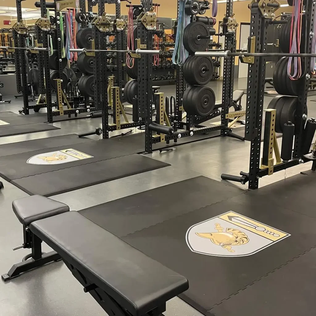Military weight room featuring engineered floor logos installed on American Platforms rubber weightlifting platforms.