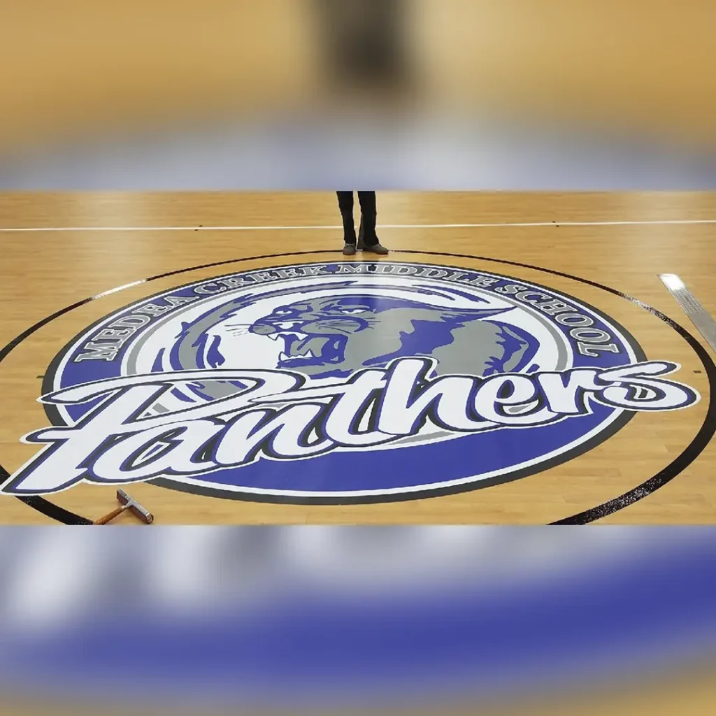 Center court logo for Medea Creek Middle School Panthers created with our engineered floor graphics technology and installed on LVT vinyl flooring.
