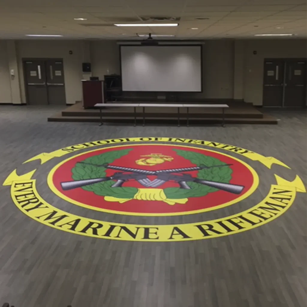 Large engineered floor graphic installed in the center of a Marine Infantry School conference hall.