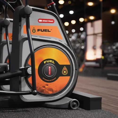 Close-up of a branded elliptical machine with gym logo prominently displayed.